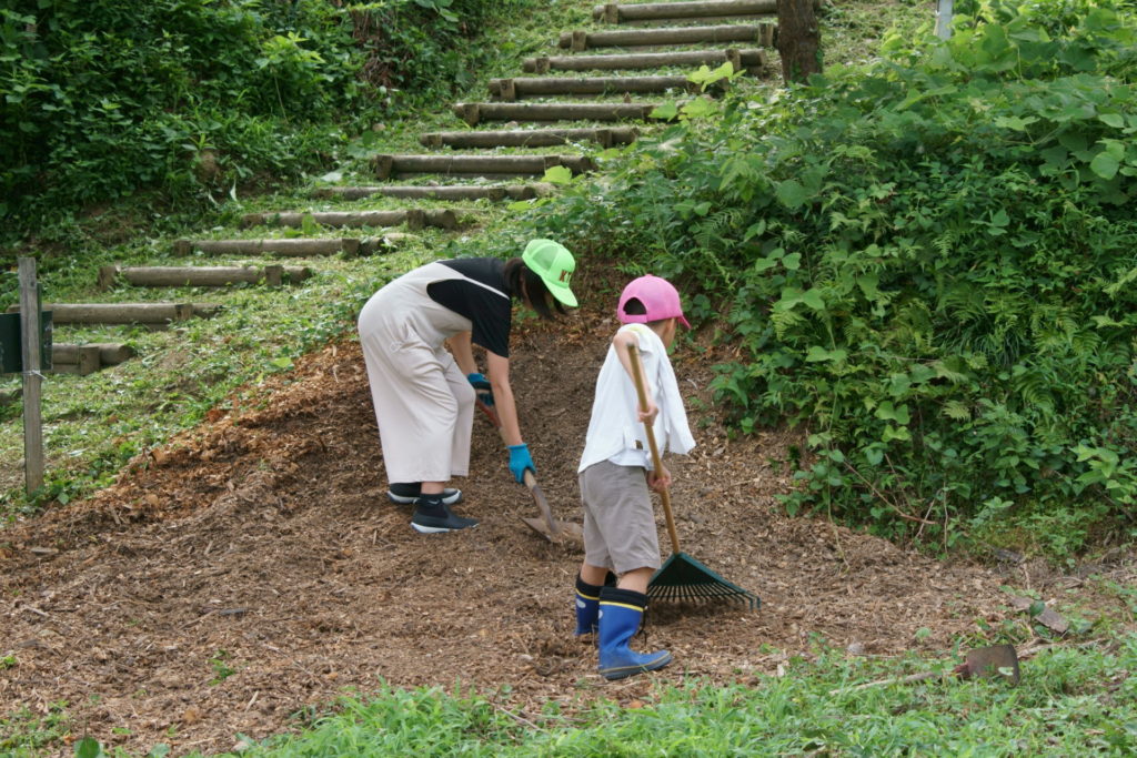 7/11の竹チップの山を均してくれています。