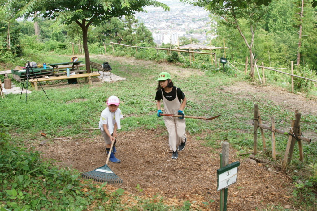 7/11の竹チップの山を均してくれています。